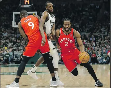  ?? — THE ASSOCIATED PRESS ?? The Raptors’ Kawhi Leonard drives to the basket against the Bucks’ Khris Middleton during the first half of Saturday night’s tilt in Milwaukee.