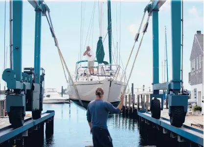  ?? SOFIE BRANDT/HARTFORD COURANT ?? Boat rigger Marc Labbe of the Noank Shipyard pulls boats out from the marina in preparatio­n for Hurricane Henri, forecast to hit the state Sunday.