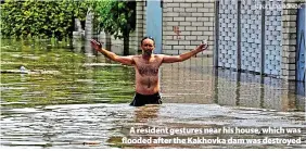  ?? NINA LYASHONOK ?? > A resident gestures near his house, which was flooded after the Kakhovka dam was destroyed