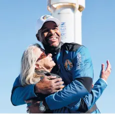  ?? MARIO TAMA/GETTY ?? Former NFL star Michael Strahan hugs Laura Shepard Churchley, daughter of astronaut Alan Shepard, Saturday after their space flight from West Texas.