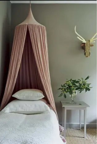  ??  ?? Right A muted pink canopy and warm stone walls in Dolly’s bedroom