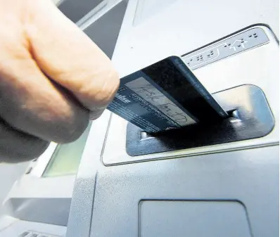  ?? FILE ?? In this file photo, a person inserts a debit card into an ATM.