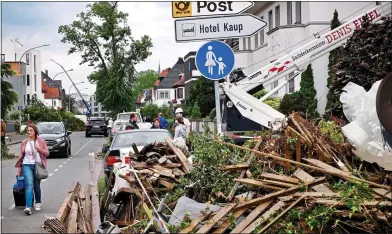  ?? ?? EXTREMES: Clear-up time in Paderborn, Germany, above, while a flamenco dancer mops her brow in Cordoba