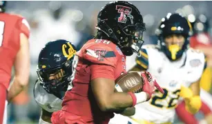  ?? ROGELIO V. SOLIS/AP ?? Texas Tech running back Tahj Brooks runs past California defenders during the first half of the Independen­ce Bowl on Saturday night in Shreveport, Louisiana. The Red Raiders won 34-14.