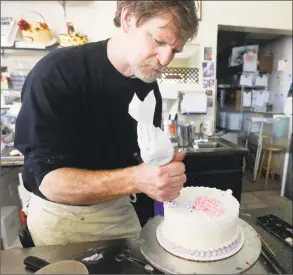  ?? Brennan Linsley / Associated Press file photo ?? Masterpiec­e Cakeshop owner Jack Phillips decorates a cake inside his store in Lakewood, Colo., in 2014. The Supreme Court set aside a Colorado court ruling against a baker who wouldn’t make a wedding cake for a same-sex couple. But the court is not deciding the big issue in the case, whether a business can refuse to serve gay and lesbian people.