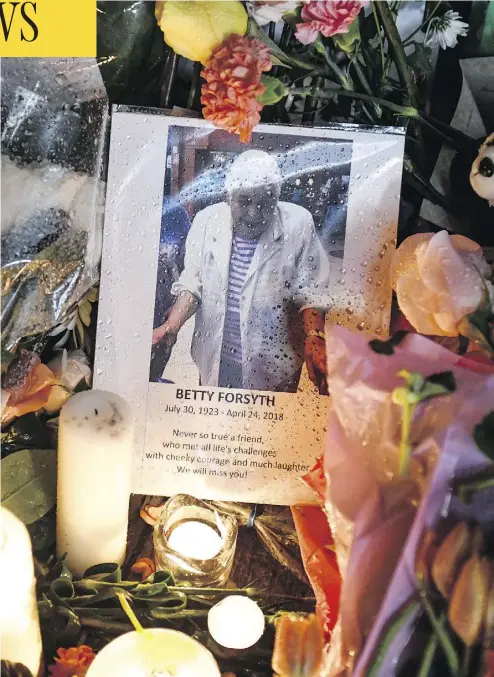  ?? GALIT RODAN / THE CANADIAN PRESS ?? A photo of Betty Forsyth is nestled among flowers and candles at a vigil on Yonge Street in Toronto Tuesday evening. The 94-year-old was one of 10 victims killed Monday when a van ran onto a sidewalk and targeted pedestrian­s.