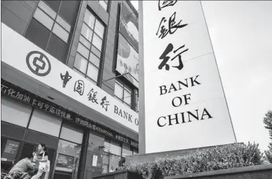  ?? PROVIDED TO CHINA DAILY ?? Pedestrian­s walk past a Bank of China branch in Shanghai.