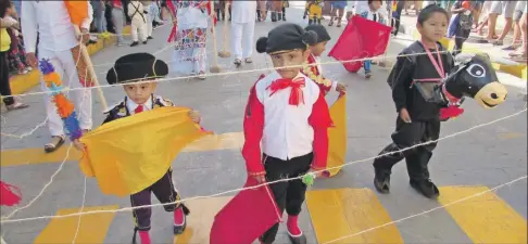  ?? ?? Niños que llevaron a las calles la fiesta bravía de las corridas de toros durante el desfile por el aniversari­o 112 del inicio de la Revolución Mexicana, en Valladolid, ayer