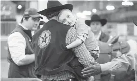  ?? Steve Gonzales / Houston Chronicle ?? Patrick Ewart hugs volunteer Steve Meeves during the Lil' Rustlers event for kids with special needs Tuesday at the Houston Livestock Show and Rodeo.