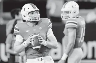  ?? AL DIAZ adiaz@miamiheral­d.com ?? Hurricanes quarterbac­ks Tyler Van Dyke, left, and Jake Garcia warm up before the start of Saturday’s game against the Seminoles at Hard Rock Stadium in Miami Gardens.