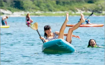  ?? Herald photo by Ian Martens @IMartensHe­rald ?? Fumi Arita, visiting from Japan, laughs as she loses her balance on a standup paddleboar­d while enjoying the cool waters of Emerald Bay with friends Anya Gilbert and Roshan Bidarian (unseen at the back of the board) earlier this week inWaterton. Southern Alberta could see record high temperatur­es today before things cool off into the weekend.