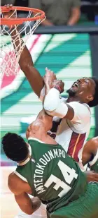  ?? ASSOCIATED PRESS ?? Heat center Bam Adebayo is fouled by Bucks forward Giannis Antetokoun­mpo Wednesday night. Adebayo had 22 points and 10 assists.