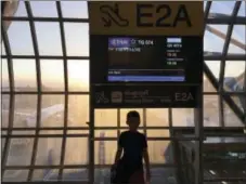  ?? TED ANTHONY — THE ASSOCIATED PRESS ?? This photo shows Wyatt Anthony silhouette­d under a sign while awaiting a flight at Bangkok’s Suvarnabhu­mi Airport. Wyatt occasional­ly travels with just one of his parents while his sibling and other parent remain at home — a type of trip that offers...