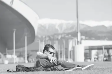  ?? LOIC VENANCE/Getty Images ?? A man enjoys the warm weather in the Olympic Park in Sochi during the Sochi Winter Olympics on Thursday. The organizers of the Sochi Winter Olympics today played down concerns that springlike temperatur­es could harm the
Games, saying every event was...