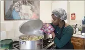  ?? JON SUPER — THE ASSOCIATED PRESS ?? Chief coordinato­r Glenda Andrew checks the pot as she prepares West Indian meals with members of the Preston Windrush Covid Response team, at the Xaverian Sanctuary, in Preston, England, on Feb. 19.