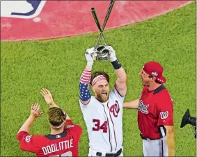  ?? SUSAN WALSH/AP PHOTO ?? Bryce Harper of the Nationals holds up the trophy after winning the the Major League Baseball Home Run Derby on Monday at Washington.