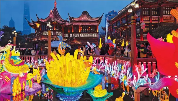  ?? ?? The iconic Zigzag Bridge at Shanghai’s Yuyuan Garden is surrounded by fish and dragon lanterns.
— Jiang Xiaowei