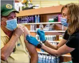  ??  ?? Dunwoody resident Randy Krafft, 64, receives his second Moderna COVID-19 vaccinatio­n from pharmacist Leslie Juhn at Concord Carlton’s Pharmacy in Dunwoody on Tuesday. The pharmacy stopped offering the Johnson & Johnson vaccine following a national pause that began Tuesday.