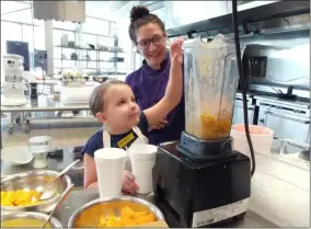  ?? PHOTOS BY ZACHARY SRNIS — THE MORNING JOURNAL ?? Marisa Goodman, culinary instructor at LCCC, teaches Allison Pelfrey, 7, of Amherst, how to make a smoothie.
