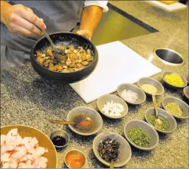  ??  ?? Harvest executive sous chef Joseph Cadina prepares kampachi poke with elements including inamona, house-made furikake and barrel-aged tamari.