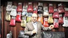  ??  ?? Alberto Reyes, son of Cleto Reyes founder of the iconic Mexican boxing gloves factory which bears his name, poses in front of a wall packed with autographe­d gloves at Reyes Industries headquarte­rs in Mexico City, on July 06, 2017. - AFP photo