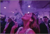  ?? RICHARD VOGEL — THE ASSOCIATED PRESS, FILE ?? A guest takes a puff from a marijuana cigarette at the Sensi Magazine party celebratin­g the 420holiday in the Bel Air section of Los Angeles on April 20, 2019.