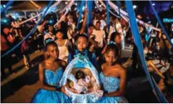  ?? — AFP photos ?? Afro-Colombians hold a basket with ‘Nino Dios’ (God Child) inside in Quinamayo, department of Valle del Cauca, Colombia.