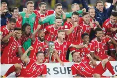  ?? — Reuters ?? Bayern Munich players celebrate with the trophy.