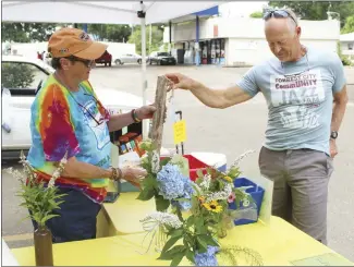  ?? Katie West • Times-Herald ?? Jenny Dearman, left, sells Mallory Nimocks a bird feeder during last week’s Farmer’s Market. The Forrest City Farmer’s Market is open each Saturday from 8 a.m. until noon. Local growers and crafters are encouraged to sign up to sell goods at the Forrest City City Hall.