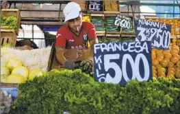  ?? Natacha Pisarenko Associated Press ?? A VENDOR arranges produce at a market on the outskirts of Buenos Aires. Food and nonalcohol­ic beverages saw an average monthly bump of 29.7% in December.