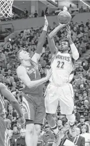  ?? Paul Battaglia / Associated Press ?? The Timberwolv­es’ Andrew Wiggins shoots over the Rockets’ Sam Dekker during the first half of Saturday night’s game at Minneapoli­s.