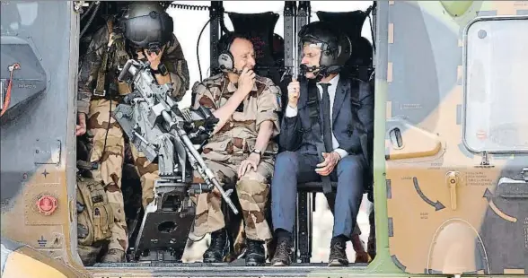  ?? CHRISTOPHE PETIT TESSON / AP ?? Emmanuel Macron, junto al jefe del Estado Mayor, a punto de despegar a bordo de un helicópter­o militar en Gao, en el norte de Mali