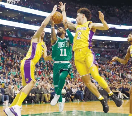  ?? . AP FOTO / WINSLOW TOWNSON ?? PASSING THROUGH. Boston Celtics guard Kyrie Irving (11) drives past Los Angeles Lakers’ Lonzo Ball (2) and Brook Lopez during the fourth quarter of Boston’s 107-96 win at home.