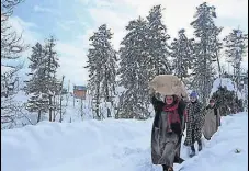  ?? AFP FILE PHOTO ?? Villagers carry rice after heavy snowfall in Srinagar.