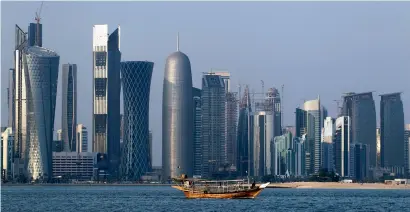  ?? — AP file ?? A traditiona­l dhow floats in the Corniche Bay of Doha with tall buildings of the financial district in the background. Qatar’s ties to Iran and embrace of various militant groups have put the country under intense scrutiny.