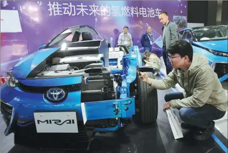  ?? XU CONGJUN / FOR CHINA DAILY ?? A visitor examines a car that uses fuel cells during an industry expo in Rugao, Jiangsu province.