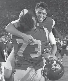  ?? JAYNE KAMIN-ONCEA, USA TODAY SPORTS ?? Southern California placekicke­r Chase McGrath hugs Austin Jackson (73) after the winning field goal against Texas.