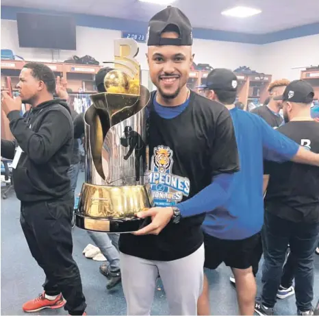  ?? ?? El dirigente Gilbert Gómez exhibe el trofeo de campeón tras la conquista del Licey de su corona 24, la cual obtuvo este sábado frente a las Estrellas. Gilbert se convirtió en el dirigente más joven en lograr un cetro en Lidom.