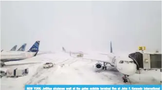  ?? —AFP ?? NEW YORK: JetBlue airplanes wait at the gates outside terminal five at John F. Kennedy Internatio­nal Airport in the Queens borough of New York City. A winter storm traveled up the east coast of the United States - dumping snow and creating blizzard...