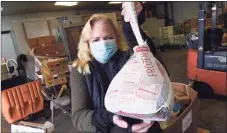  ?? Arnold Gold / Hearst Connecticu­t Media ?? Kate Lombardi, executive director of the Food Bank of Lower Fairfield County, holds a package of frozen turkey breasts.