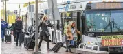  ?? JOHN SPINK / JSPINK@AJC.COM ?? MARTA riders headed to the airport board shuttle buses at the College Park station on Thursday. A derailed MARTA train caused disruption­s.