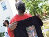  ?? Arnold Gold / Hearst Connecticu­t Media ?? Jameson Davis, of Hamden, displays a shirt of his cousin, Samod “Nuke” Rankins, after the prayer vigil.