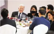  ?? EVAN VUCCI/ASSOCIATED PRESS ?? President Joe Biden shares a light moment with people at a table with South Korean President Yoon Suk Yeol (back right) at a state dinner at the National Museum of Korea, Saturday in Seoul.