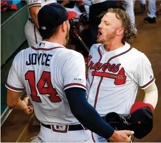  ?? CURTIS COMPTON / CCOMPTON@AJC.COM ?? Braves third baseman Josh Donaldson tries to get outfielder Matt Joyce fired up before Tuesday’s game against the Phillies at SunTrust Park.