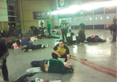  ?? — AP ?? Helpers attend to injured people inside the Manchester Arena, in Manchester, UK, after a blast on Tuesday.