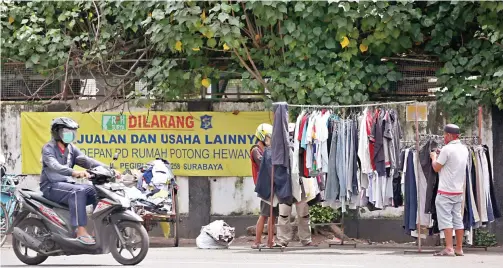  ?? AHMAD KHUSAINI/ JAWA POS ?? DIBATASI: Pedagang kaki lima di sekitar Rumah Potong Hewan Pegirian diminta tidak berjualan setelah jam 10 pagi.