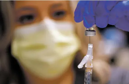  ?? PHOTOS BY LUIS SÁNCHEZ SATURNO/THE NEW MEXICAN ?? ABOVE: Alejandra Salinas, an emergency room registered nurse at Christus St. Vincent Regional Medical Center, prepares a dose of the COVID-19 vaccine Dec. 18.