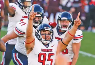  ?? AP PHOTO/ MATT GENTRY ?? Liberty kicker Alex Barbir celebrates after making a last-second field goal in the Flames’ 38-35 win at Virginia Tech on Nov. 7. Liberty is 8-0 and No. 21 in the AP Top 25 this week.