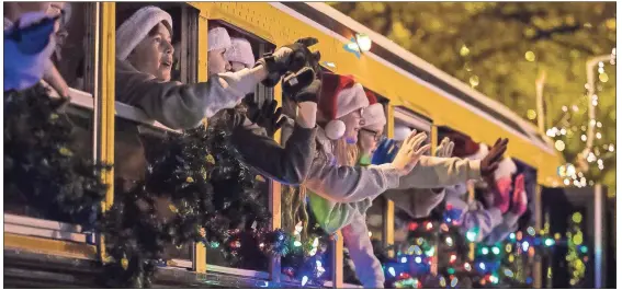  ??  ?? ABOVE: St. Mary Catholic School students wave to the crowd from their decorated school bus during the Rome Christmas parade on Tuesday night. BELOW: For the first time, Mrs. Claus joins Santa for the ride up Broad Street during the 2018 Rome Christmas parade. ON THE WEB: Visit RN-T.com to see a parade photo gallery.