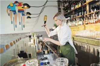  ?? GAVIN YOUNG ?? Bartender Dinah Kisil mixes drinks at the new Bridgette Bar, which blends excellent food with a great wine, beer and cocktail menu in a stylish mid-century modern setting.